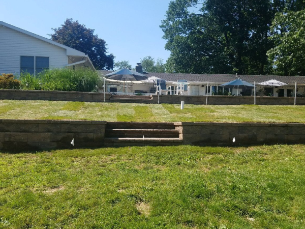 custom retention wall with lawn maintenace in backyard with steps