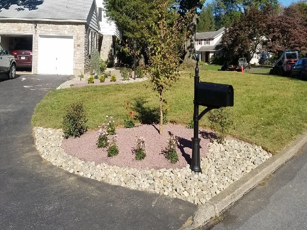 stone landscape with flowers around mailbox