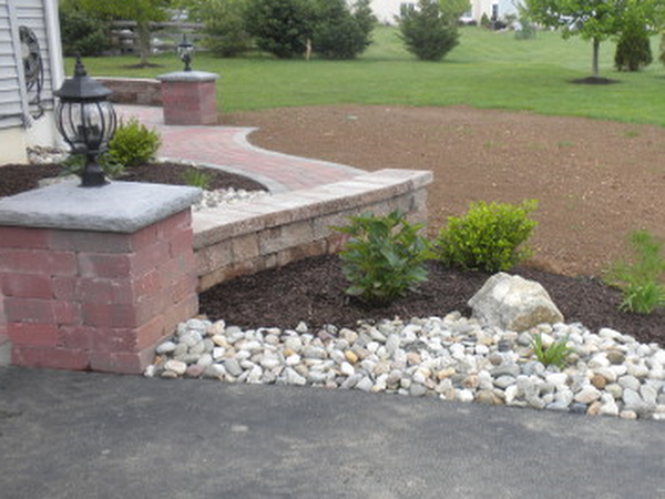 backyard landscaping with rocks, mulch, and plants