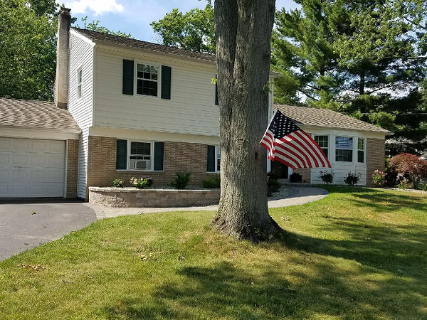 front lawn landscape with retaining wall and American Flag