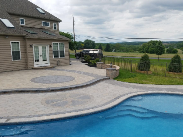 aerial view of backyard with pool, paver patio, and lighting